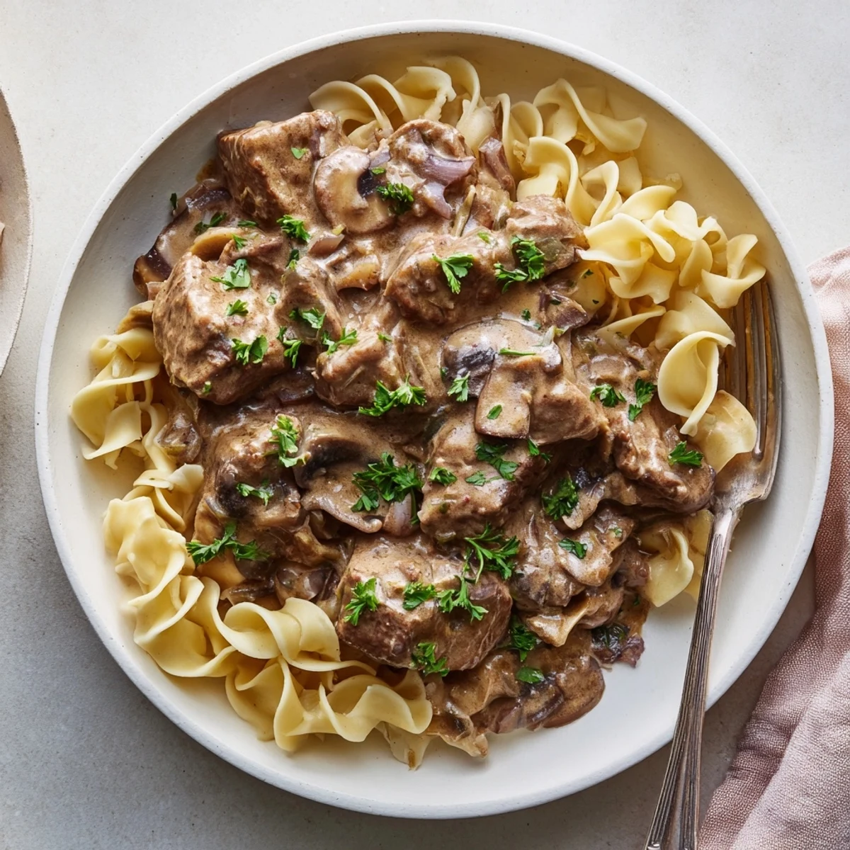 Creamy mushroom sauce enveloping beef in slow cooker beef stroganoff, served with mashed potatoes.  