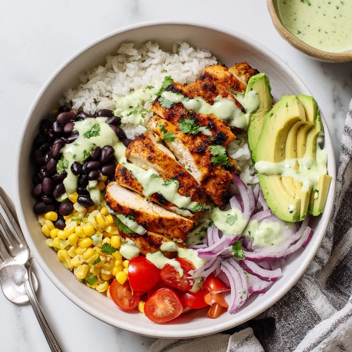 Flavorful Zesty Lime Cilantro Chicken Bowls drizzled with tangy dressing in a hearty serving.  