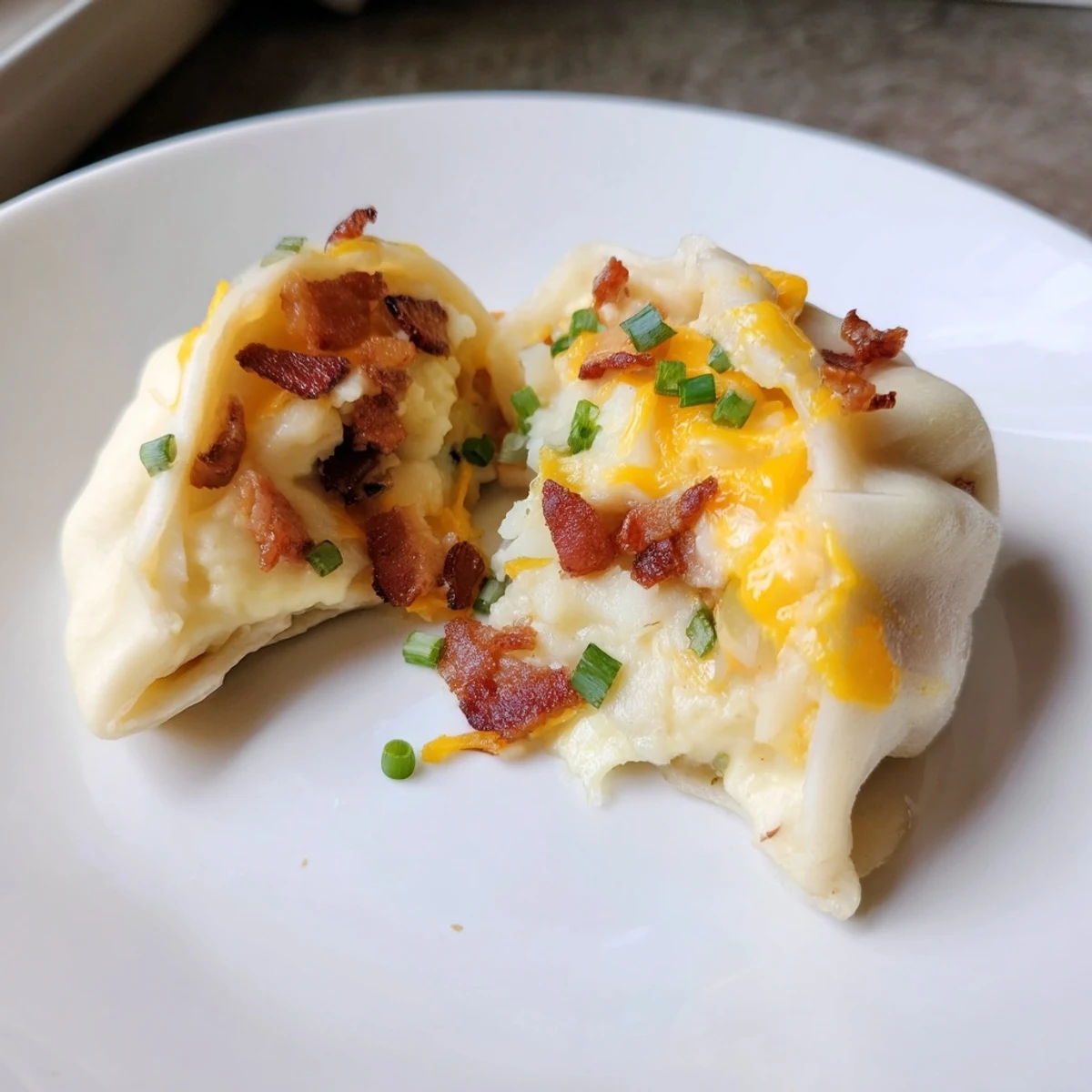 Steaming loaded baked potato soup dumplings, golden brown with visible cheese and crispy bacon, ready to enjoy.