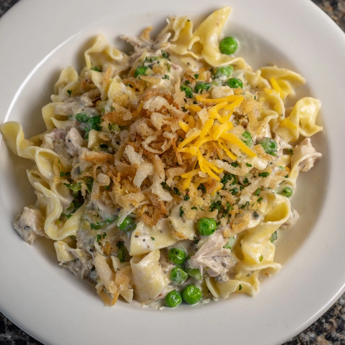 Warm, bubbling tuna noodle casserole topped with crispy onions, ready for scooping and serving.