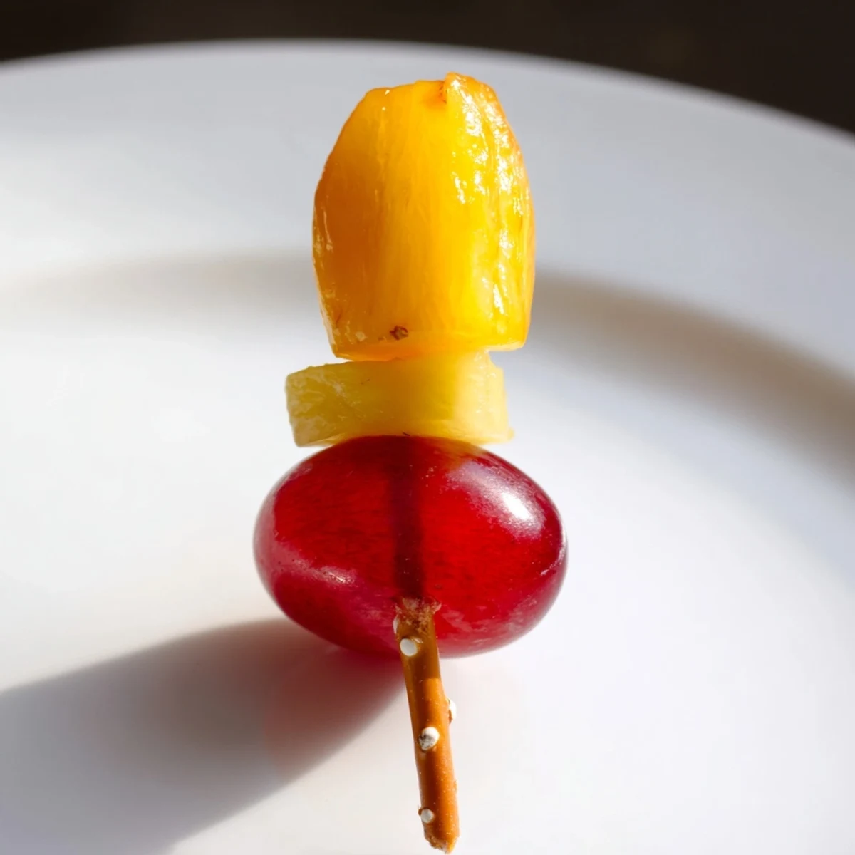 Vivid Christmas Light Fruit Skewers showcase ripe grapes, strawberries, and pineapple, perfect for a cheerful snack.