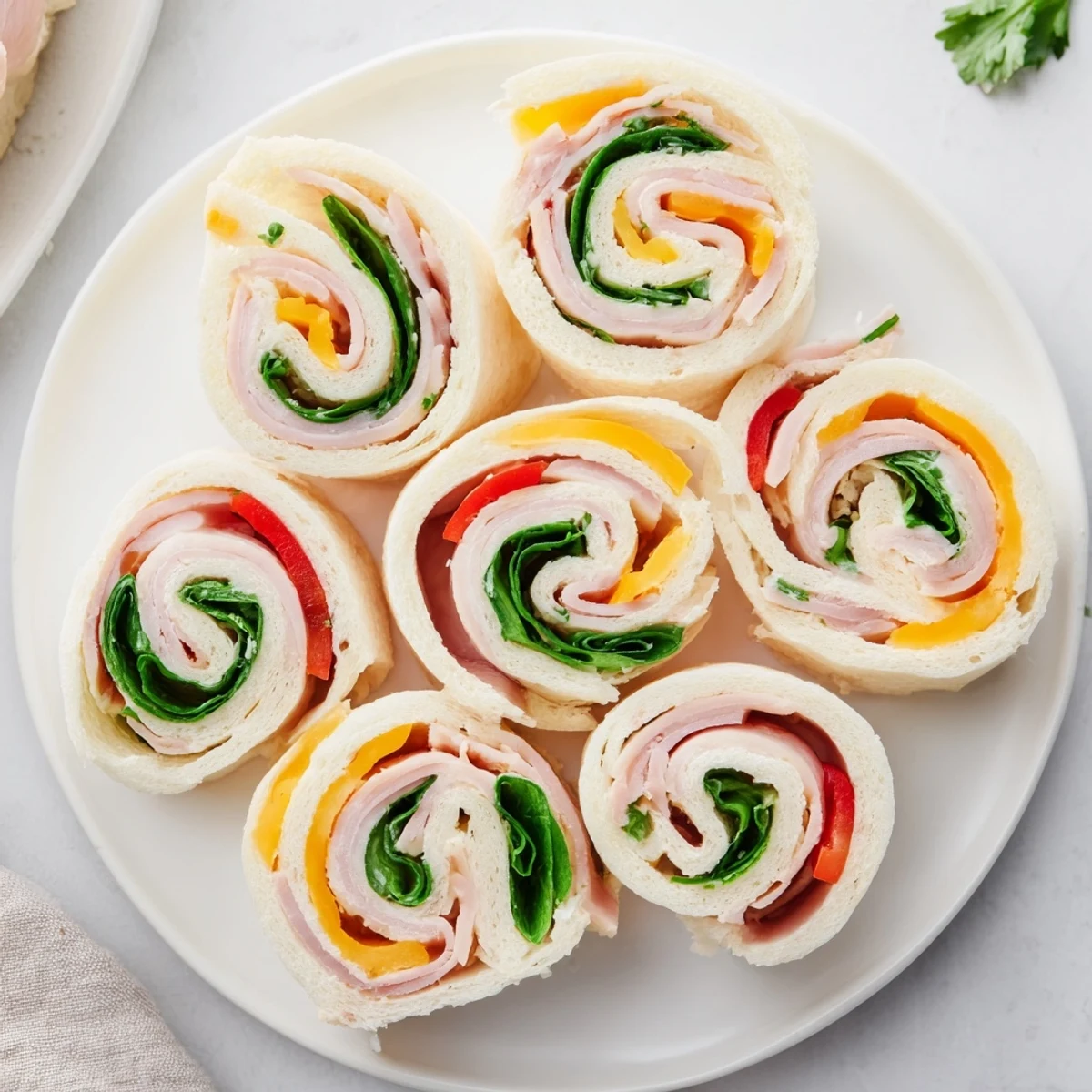 Party Sandwiches: Star-shaped deli roll-ups, vibrant with meat and cheese fillings, ready for a gathering.