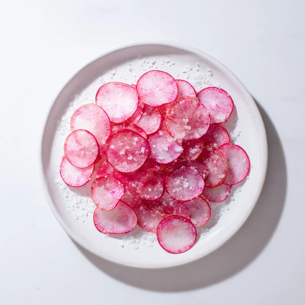 Crisp radish slices glistening with sea salt, ready to eat as an easy, healthy snack.