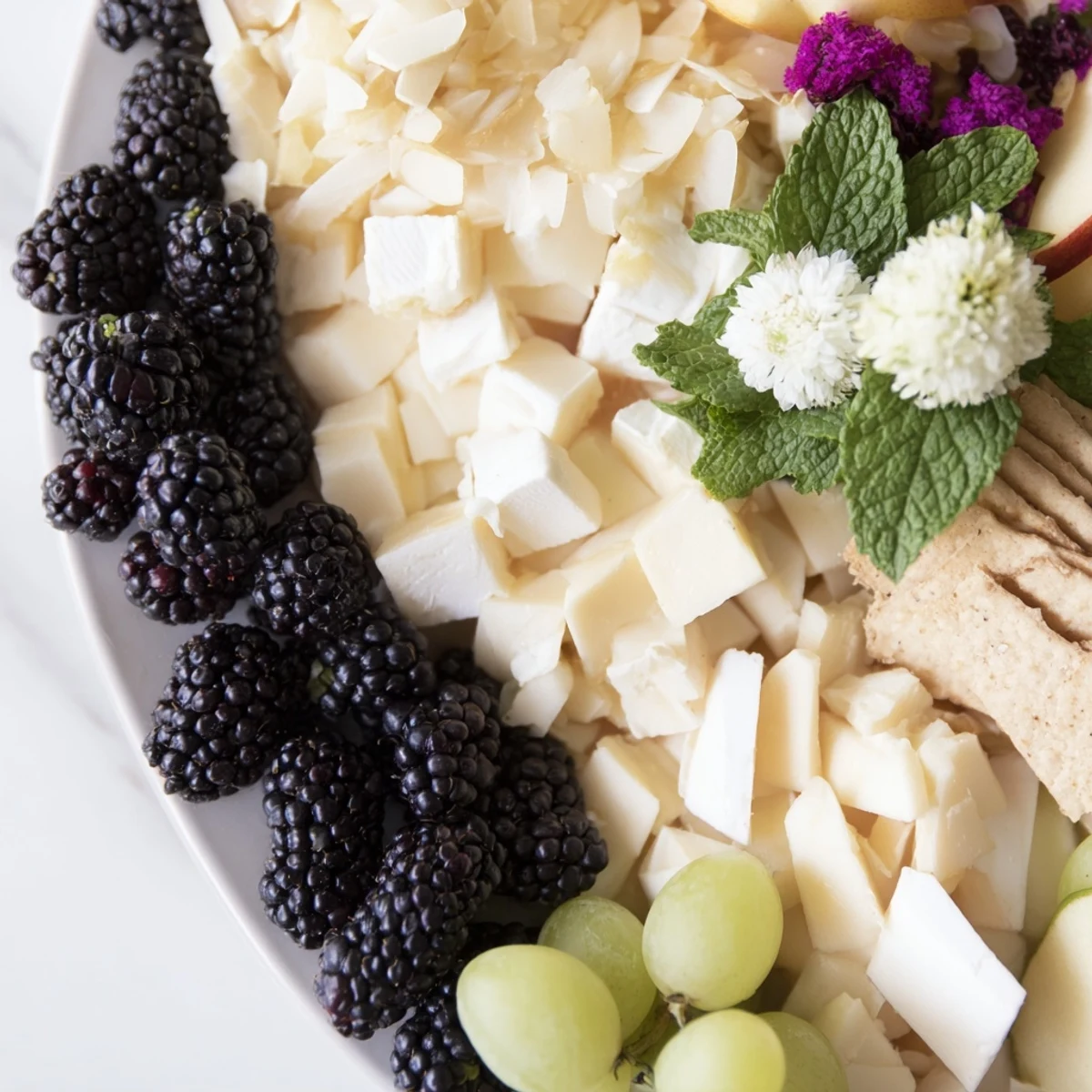 Vibrant Yin-Yang Balance: See the artful arrangement of fruits, cheeses, and crackers for a delicious treat.