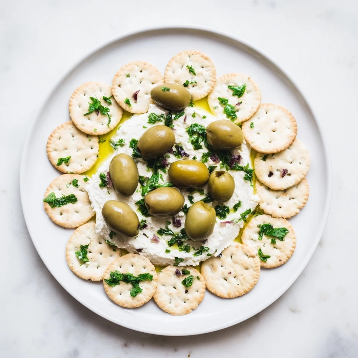 Vibrant Cobblestone Courtyard appetizer with green and black olives nestled between crackers ready to serve.
