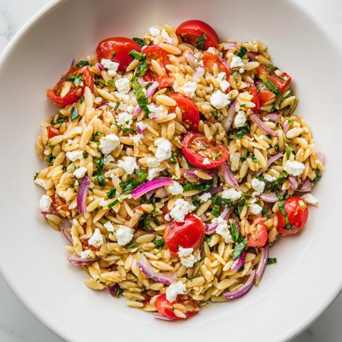 Fresh, vibrant Tomato Feta Orzo pasta salad, featuring juicy red tomatoes and creamy feta cheese.