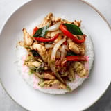 Aromatic Thai Basil Chicken Bowls served atop fluffy rice, garnished with fresh lime wedges for zest.