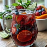 Refreshing Iced Hibiscus Berry Tea garnished with mint and sliced citrus.