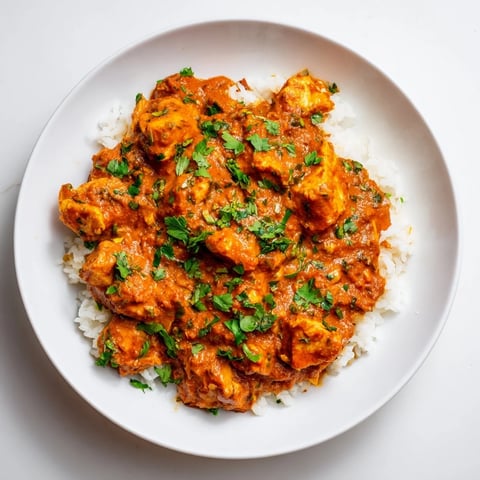 A vibrant bowl of creamy Instant Pot Chicken Tikka Masala, accented with fresh cilantro for serving.