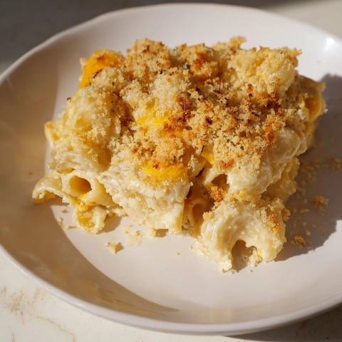 Golden-brown baked mac and cheese bubbling in a dish, ready for serving after a perfect bake.