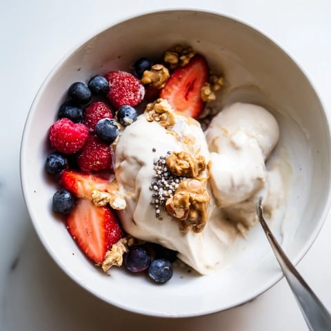 A vibrant ice cream bowl overflowing with protein ice cream, fresh berries, and crunchy granola.