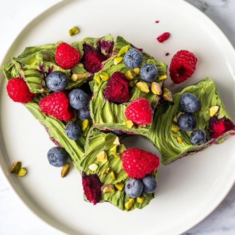 Creamy Frozen Yogurt Bark, swirled with matcha and berry purees, ready for a refreshing bite.