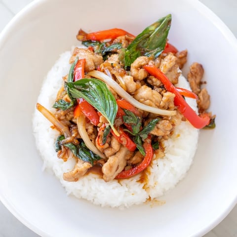 Steaming Thai Basil Chicken Bowls, a flavorful stir-fry with vibrant basil and tender chicken.