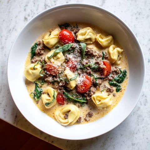 A cozy bowl of Tortellini Beef Soup with creamy broth, tender pasta, and juicy cherry tomatoes.
