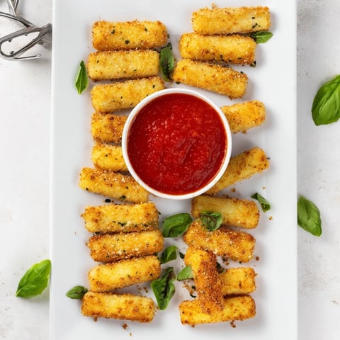 Air Fryer Mozzarella Sticks with golden crispy breading and gooey melted cheese, served with warm marinara dip and fresh basil garnish.