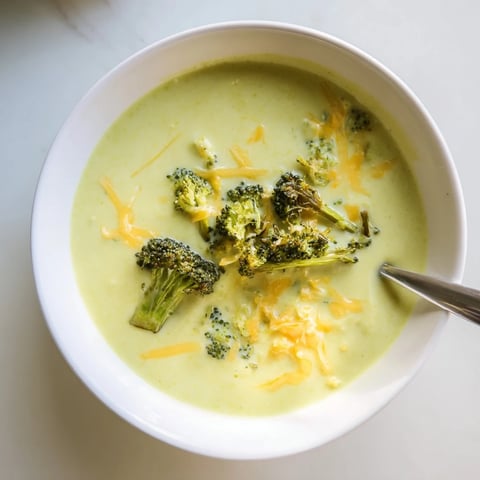 Creamy Broccoli Cheddar Soup in a rustic bowl with roasted broccoli florets and melted cheddar garnish.