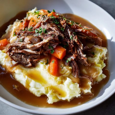 A close-up of a plated, delicious Slow Cooker Pot Roast with hearty vegetables and potatoes.