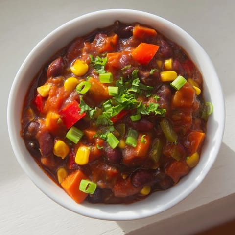 This warm, vibrant veggie chili showcases a medley of beans and perfectly cooked vegetables, ready to serve.