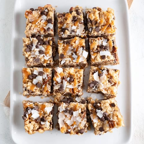 Delicious, layered 7-Layer Magic Bars topped with sweet caramel sauce and crunchy nuts.