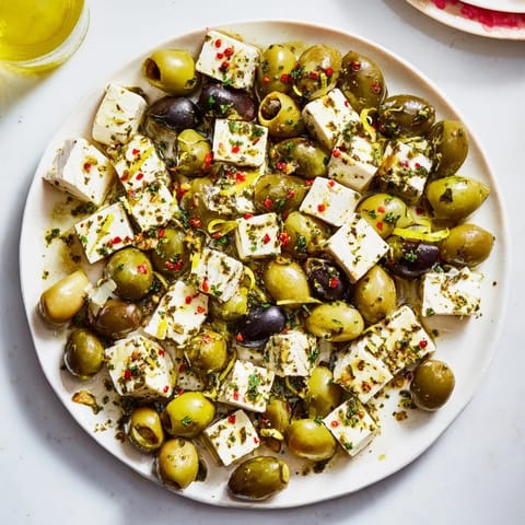 Vibrant Holiday Mix: Mixed Olives with Feta Cubes, glistening with olive oil and fresh herbs.