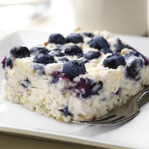 A close-up shot of a creamy, high-protein Blueberry Cottage Cheese Bake with juicy berries.