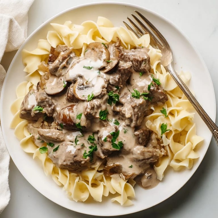 Delicious slow cooker beef stroganoff blending savory spices with rich sour cream sauce.