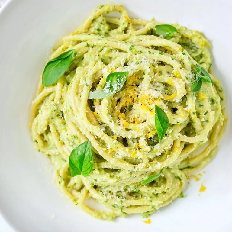 Plate of creamy avocado pasta, with a swirl of noodles, offering a refreshing and flavorful bite.