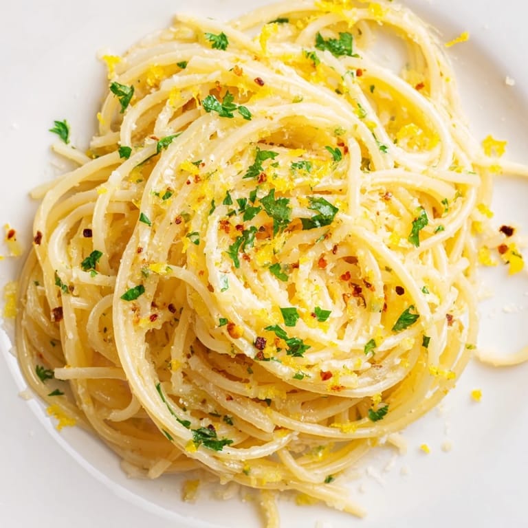 Golden-hued Garlic Butter Noodles speckled with herbs, bringing a comforting aroma to your kitchen table.