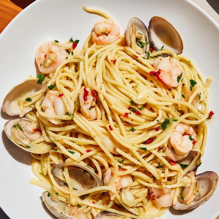 Enjoy a delicious bowl of Seafood Pasta Aglio e Olio – a vibrant Italian seafood feast with garlic and chili.