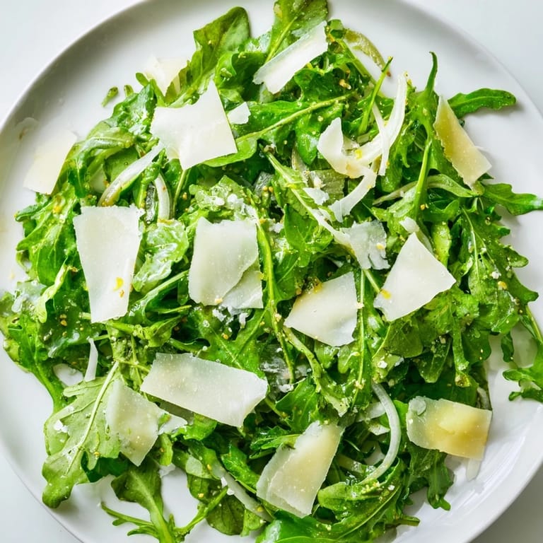 Shaved Parmesan and peppery arugula star in this easy, homemade arugula salad with lemon dressing.