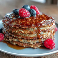 Golden brown High Fiber Protein Pancakes piled high, drizzled with syrup.